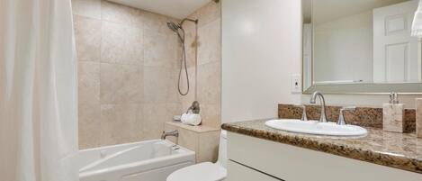 A bathroom with a bathtub, toilet, sink, and shower.