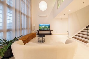 A modern living room with a large sofa, a round coffee table, and a flat-screen TV on a stand. - 3R3B Duplex Penthouse KLCC Novo Ampang Gleneagles (Kuala Lumpur)