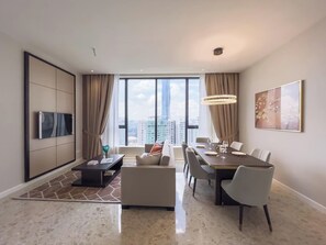 Una sala de estar moderna con comedor, ventanas amplias y vista a la ciudad.
