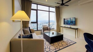 A modern living room with a sofa, coffee table, and TV. - 2BR Luxury Living KLCC 600mbps (Kuala Lumpur)