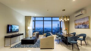 A modern living room with a city view, a dining area, and a TV on the left.