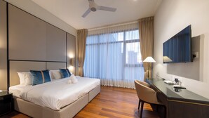 Ein modernes Hotelzimmer mit einem großen Bett, einem Schreibtisch und einem Stuhl.