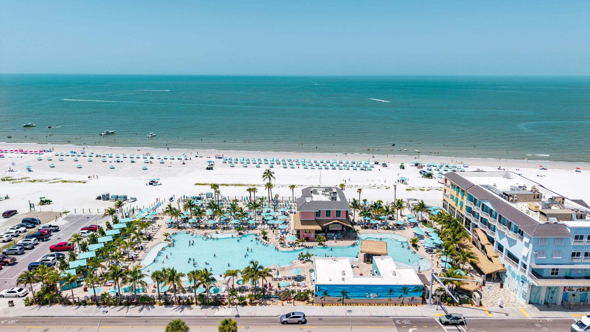 Un complexe hôtelier doté d’une grande piscine, d’une plage et de plusieurs bâtiments.