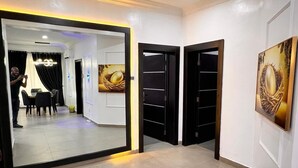 A hotel lobby with a modern design, featuring a large mirror, black-framed doors, and artwork on the walls. - The Global Enterprise (Lagos)