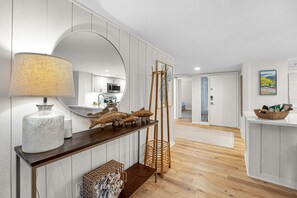 A modern kitchen with white cabinetry, a wooden countertop, and a large mirror. - Updated Sea Pines Villa on Atlantic Dunes 9th Fairway, Walk to Golf & Beach (Hilton Head Island)