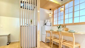 A modern kitchen with wooden furniture, a dining table, and a window with a view. - H401 ＊[New] Tokyo luxury guesthouse｜Japanese style 2DK｜Honjo-Azumabashi station & direct airport access｜Near Asakusa & Skytree (墨田区)