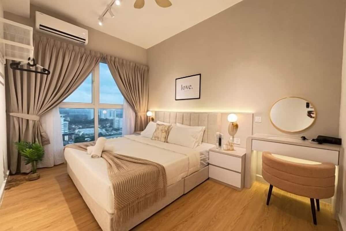 Un dormitorio moderno con una cama, mesitas de noche, un tocador con espejo y vistas a la ciudad.