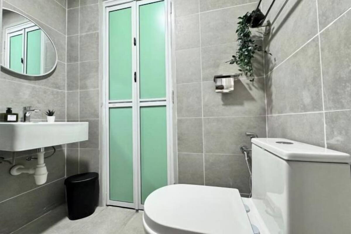 Un baño con un lavamanos blanco, un inodoro y una puerta verde.