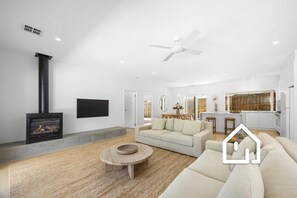 Smart TV, lareira, livros, aparelho de som