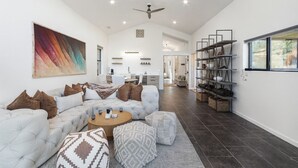 A spacious living room with a sectional sofa, a coffee table, and a bookshelf. - Sedona At the Wild Horse, Wellness Retreat, Gameroom, Cold Plunge, West & Dry Sauna (Sedona)