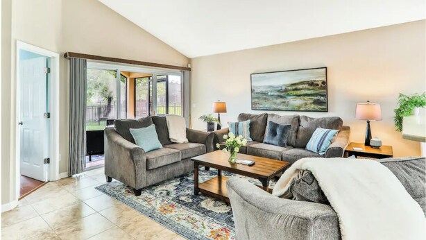 A spacious living room with two sofas, a coffee table, and a painting on the wall.
