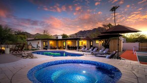 A pool area with lounge chairs, a hot tub, and a patio with a view of mountains. - Mini Resort w/ Mountain Backdrop | Heated Pool, Hot Tub, Sauna, Cold Plunge (Phoenix)