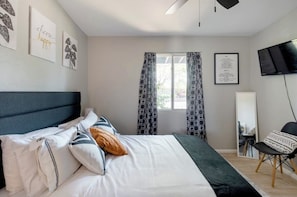 A bedroom with a bed, a chair, a TV, and a window with patterned curtains. - 3-bedroom house in peaceful Central Phoenix with Pool  GCU, Uptown, and DT (Phoenix)