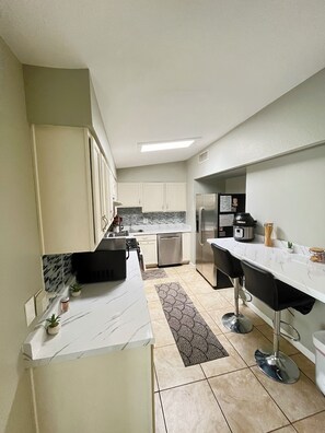 A modern kitchen with white cabinets, a marble countertop, and a built-in oven. - 3-bedroom house in peaceful Central Phoenix with Pool  GCU, Uptown, and DT (Phoenix)