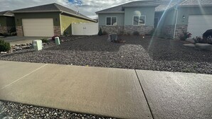 A residential area with two houses, a driveway, and a gravel front yard. - Sophisticated 4 Bedroom Retreat (Montrose)