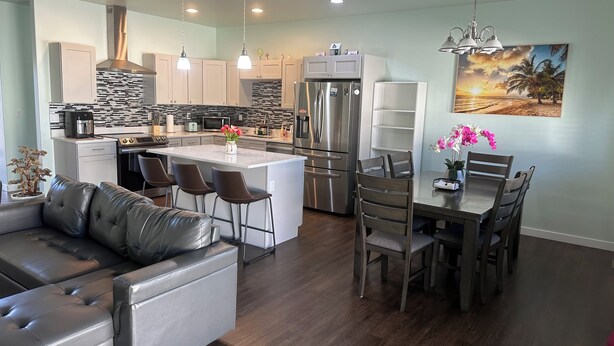 A modern kitchen with a central island, stainless steel appliances, and pendant lighting. - Sophisticated 4 Bedroom Retreat (Montrose)