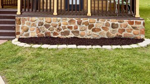 A lodge with a stone foundation, a wooden porch, and a green roof. - Rustic Lake Cabin #215 with Pool and Lake Access (Willis)