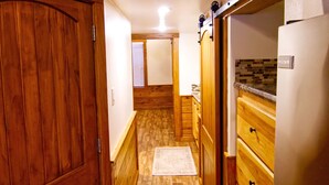 A wooden interior with a kitchen area, wooden cabinets, and a built-in refrigerator. - Rustic Lake Cabin #215 with Pool and Lake Access (Willis)