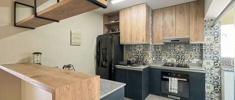 Frigorífico, microondas, cafetera o tetera y utensilios de cocina