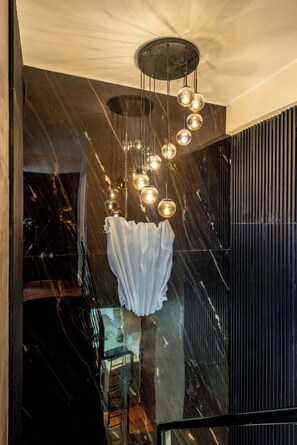 Ein modernes Interieur mit einer hängenden Leuchte und einer reflektierenden Oberfläche.