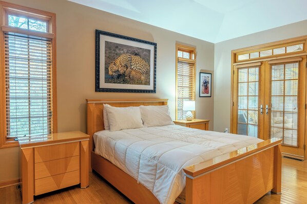 A bedroom with a wooden bed, a nightstand, a framed leopard picture, and a wardrobe. - The Reserve: Spacious 4BR home in South Haven, ultimate getaway (South Haven)