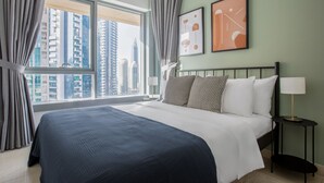 A hotel room with a large bed, a nightstand, a lamp, and two framed abstract artworks on the wall. - Blueground | Burj Residence Phase I & II, pool, nr Burj Khalifa (Dubai)
