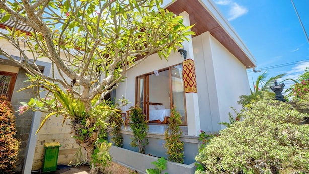 A modern building with a balcony, a bed, and a small garden area. - Moringa Pandawa Guest House (Kutuh)