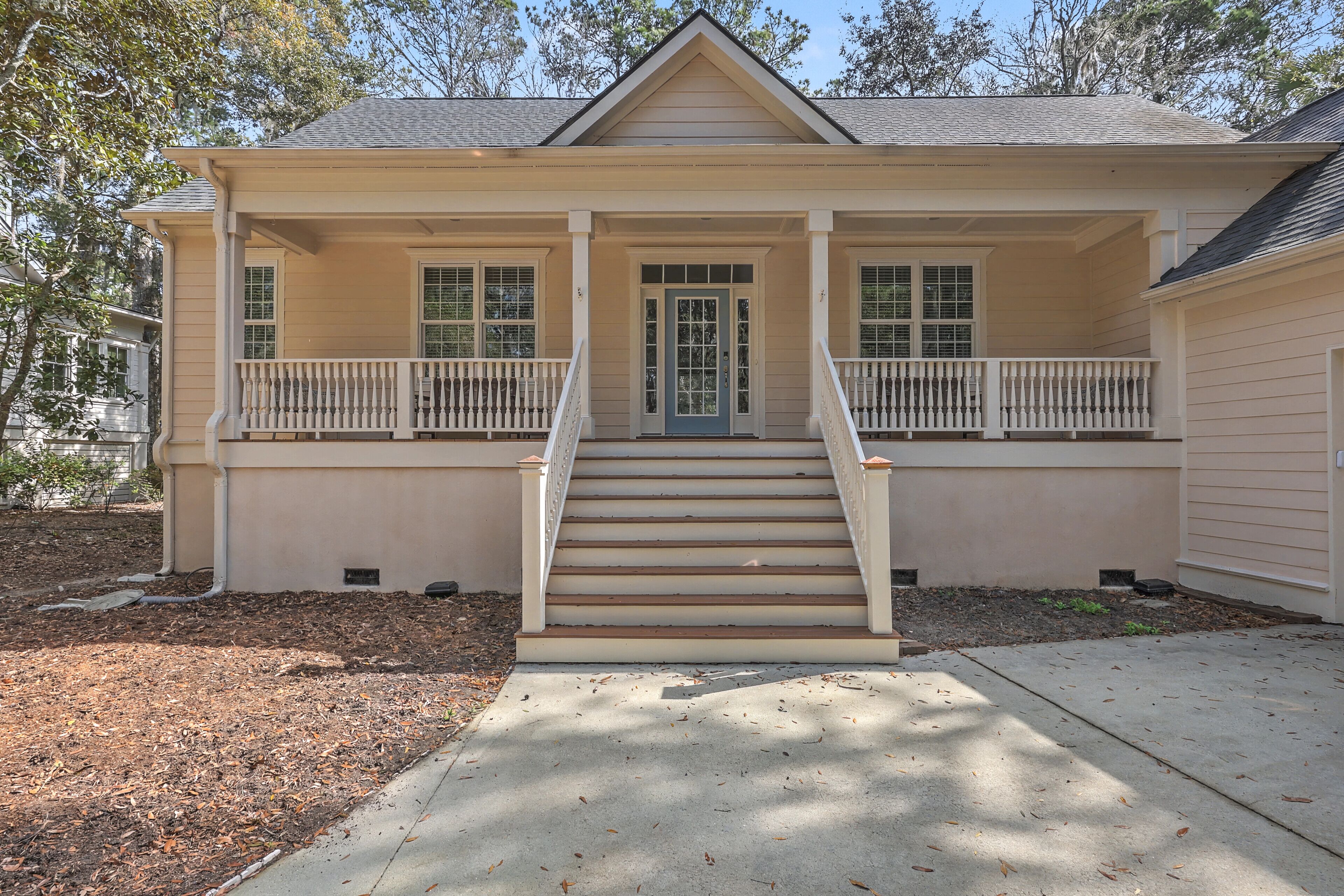 A two-story house with a front porch, a front door, and a staircase leading to the entrance.