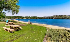 Lakeside beach and picnic area bordered by grassy lawns and clear blue water. - Cozy Mountain Retreat with Hot Tub & Game Room (Groveland)