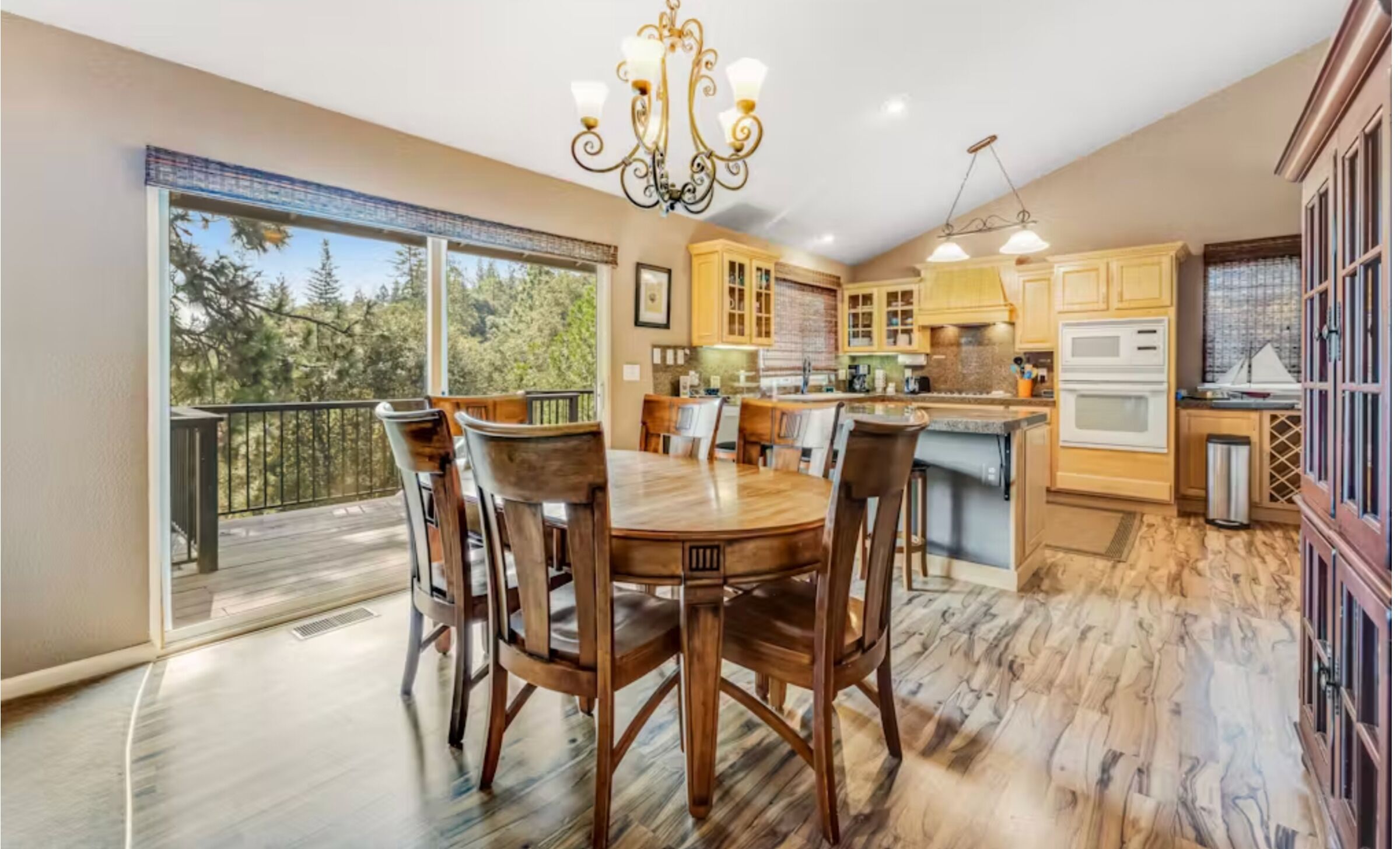 Dining area with a wooden table and deck access adjacent to the kitchen.