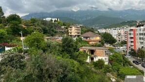 Un barrio residencial en una ladera, con casas y una carretera.