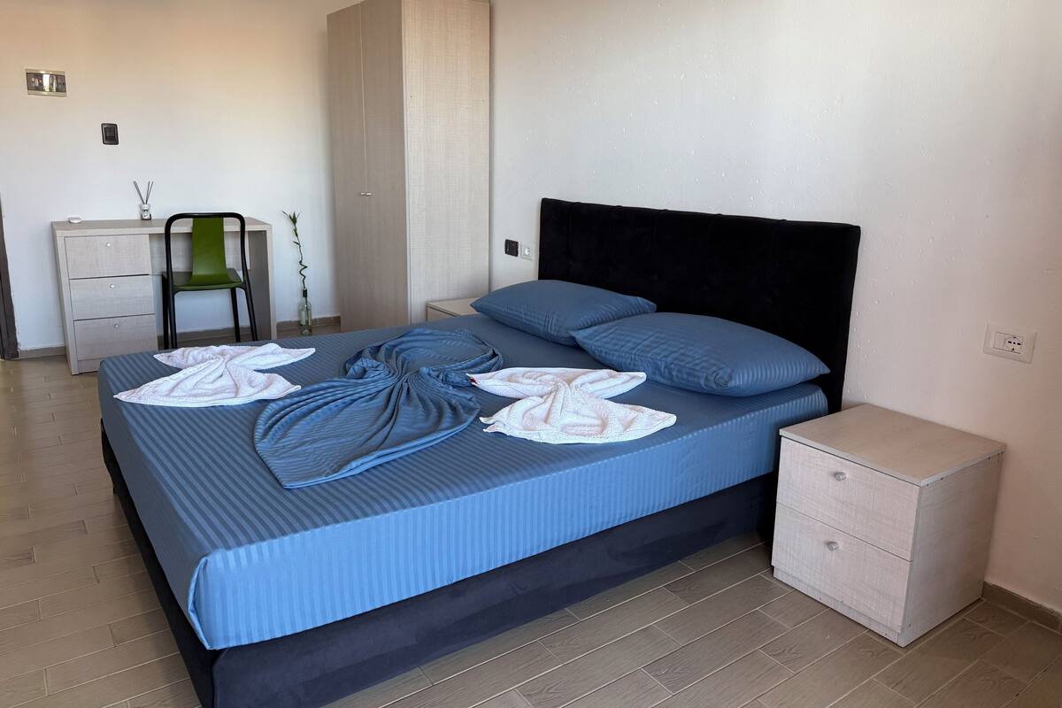 A bedroom with a bed, a nightstand, a dresser, and a chair.