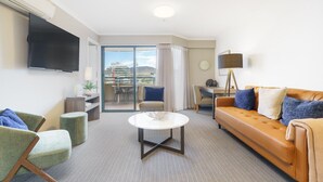 A modern hotel room with a sofa, armchair, and a dining area. - Central 2BR apartment, Hotel vibe, Walk everywhere (Braddon)
