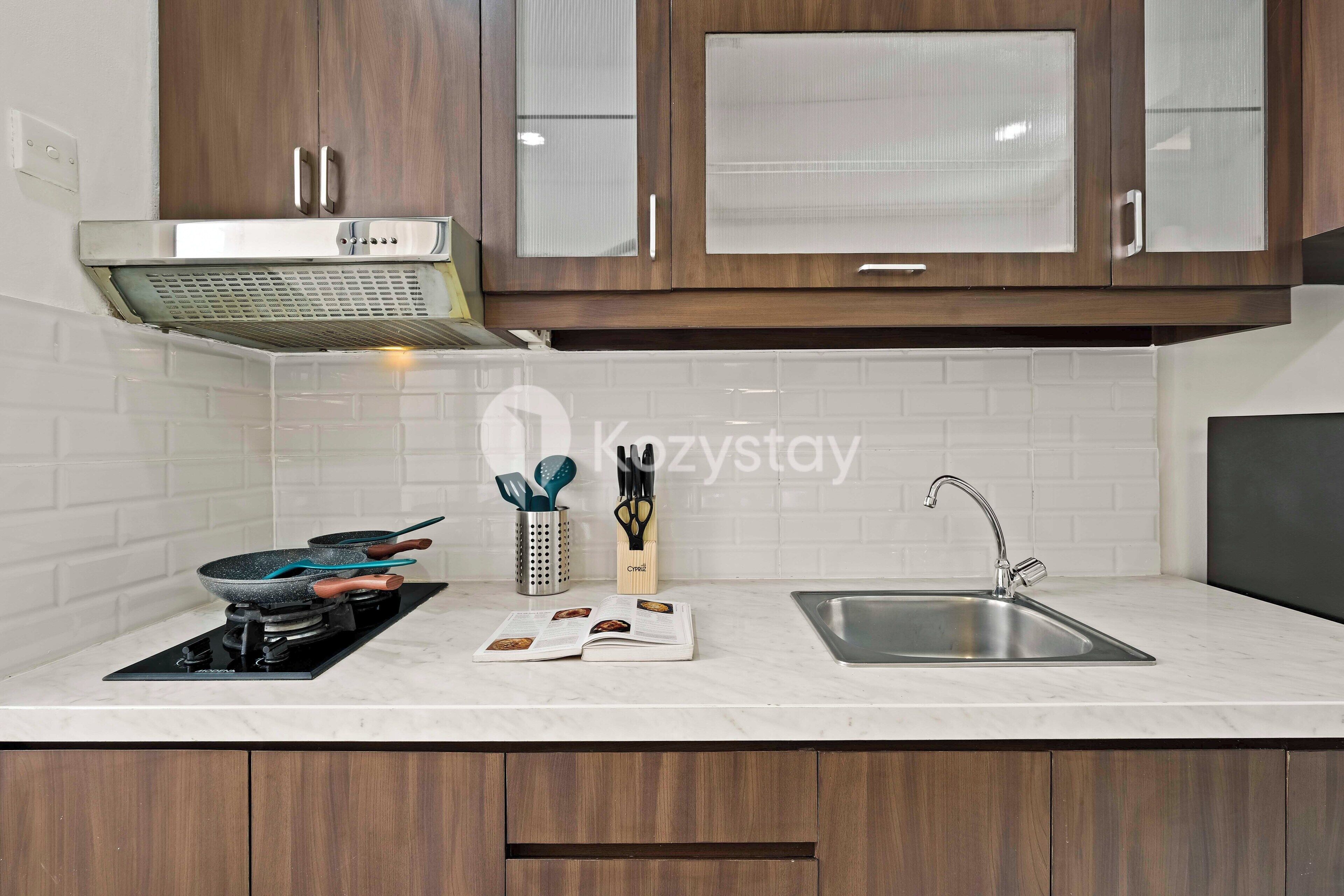A modern kitchen with a built-in stove, a sink, and wooden cabinets.