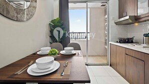 Un coin repas avec une table dressée pour quatre personnes, un miroir et une vue sur le balcon.