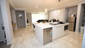 Une cuisine moderne dotée d’un îlot central, d’un four encastré et d’un lave-vaisselle.