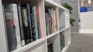 Une bibliothèque contenant divers ouvrages, notamment des titres tels que « Frederic Forsyth » et « Thérapie axée sur la qualité de vie ».