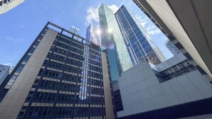 A view of modern high-rise buildings with reflective glass facades and a clear blue sky. - Modern CBD Apartment | Pool, Sauna & Laneway Dining (Melbourne)