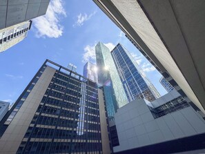 Udsigt over moderne højhuse med spejlbemmede glasfacader og en klar, blå himmel.