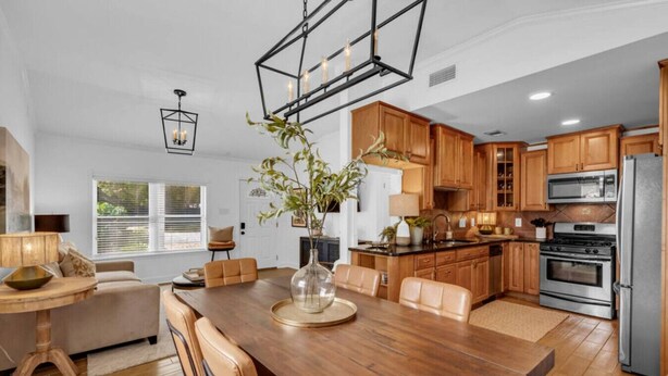 Une cuisine moderne avec des meubles en bois, un îlot central et des appareils électroménagers en acier inoxydable.
