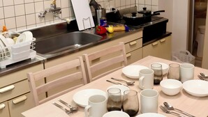 Et moderne køkken med spiseplads, der har en stålvask, komfur og et flisebeklædt bagpanel.