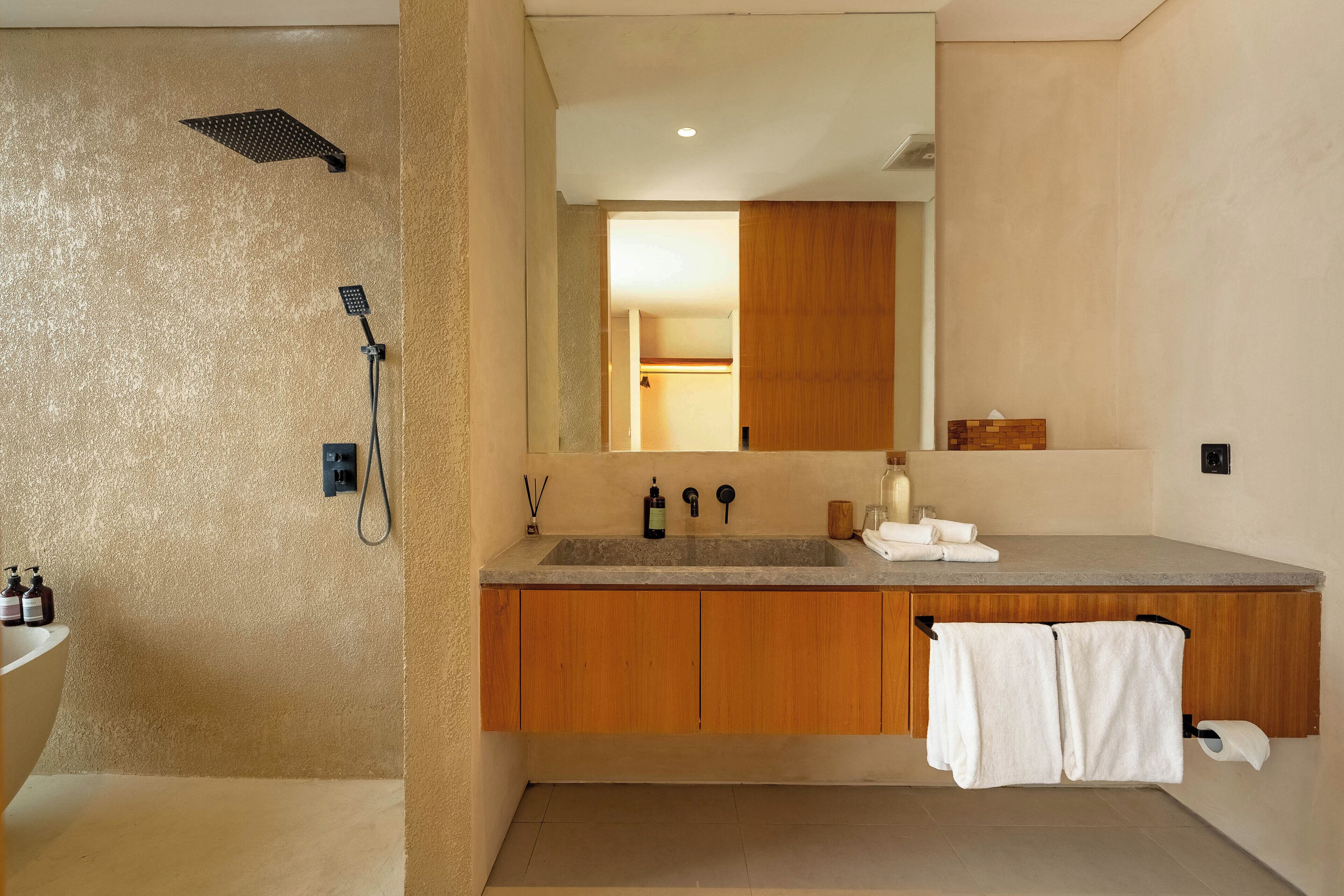 Un baño moderno con ducha, lavamanos y armarios de madera.