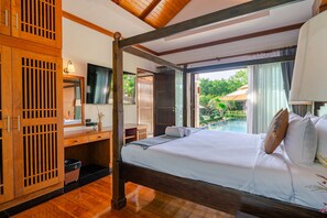 Habitación de hotel con cama, escritorio, televisor y vista a una piscina al aire libre.