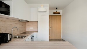 Una cocina moderna con encimera de madera, pileta de acero inoxidable y horno empotrado.