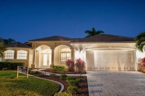 A residential house with a garage, a driveway, and a well-maintained lawn. - Boaters Dream, S. Terr, Pool, Yacht Club, Boating (Cape Coral)