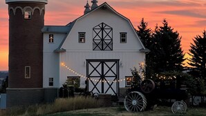 A white barn with a brick tower, a large barn door, and a wheelbarrow in front. - Famous tranquil GreenBluff barn on 10 acres, huge views, north Spokane (Colbert)