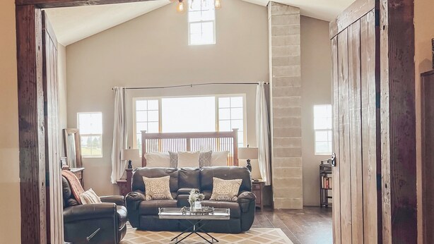 A spacious living room with a high ceiling, a large window, and a fireplace. - Famous tranquil GreenBluff barn on 10 acres, huge views, north Spokane (Colbert)