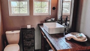 A bathroom with two windows, a white sink, a mirror, and a wooden vanity. - Famous tranquil GreenBluff barn on 10 acres, huge views, north Spokane (Colbert)