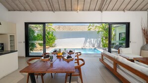 Une cuisine moderne avec un coin repas, une piscine et un canapé.