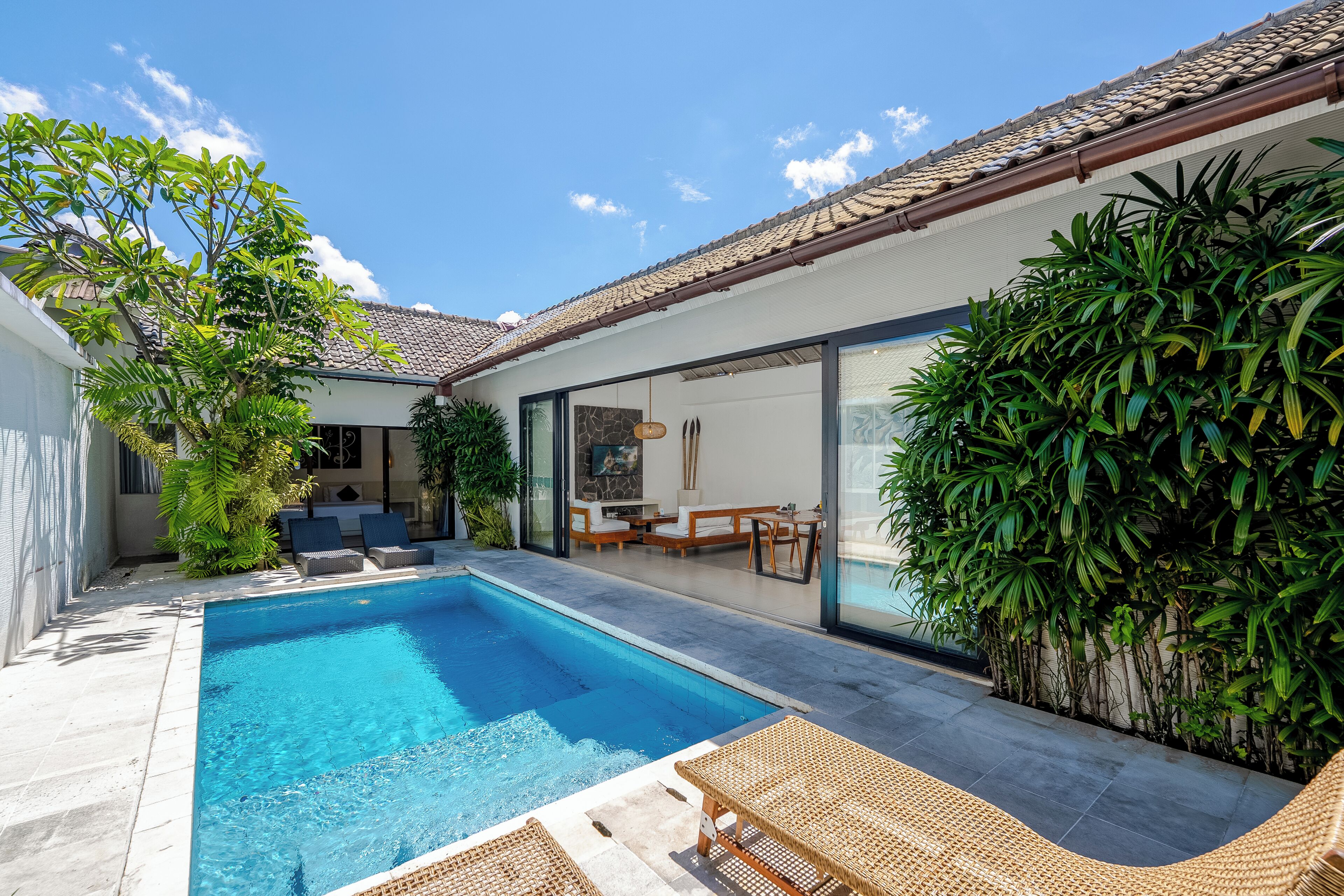 A swimming pool with lounge chairs, a patio area, and a view of the house.